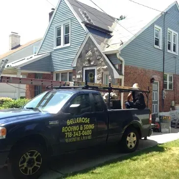 Bellerose Roofing & Siding company truck parked outside a house under repair